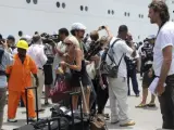 Periodistas, operarios y pasajeros del crucero 'Costa Allegra' se mezclan en durante la recogida de equipajes en el muelle del puerto de Victoria, en la isla de Mahé, Seychelles.