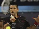 El tenista serbio Novak Djokovic devuelve la bola durante el partido de cuartos de final del torneo de Dubai.