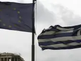 La bandera griega ondea junto a la de la Unión Europea frente al templo del Partenón de la Acrópolis de Atenas.