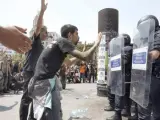 Imagen correspondiente a los altercados del pasado 27 de mayo de 2011 en la Plaza Cataluña de Barcelona, en la que miembros de la acampada del 15-M, que fue desmantelada, intentan tranquilizar a los antidisturbios.