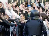 Estudiantes protestan antes los agentes antidisturbios en la plaza del Ayuntamiento de Valencia.