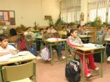 Los alumnos realizan sus tareas en la clase de un colegio.
