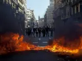 Un coche y diversos contenedores (en la foto) han resultado quemados durante los incidentes registrados en la confluencia de las calles Diputación y Balmes de Barcelona, al final de una manifestación de universitarios contra los recortes del gobierno catalán.