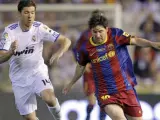 El delantero argentino del Barcelona Lionel Messi (d) pelea un balón con el centrocampista del Real Madrid Xabi Alonso.