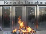 Un piquete de unas mil personas, algunas con los rostros cubiertos, ha provocado durante el desarollo de la huelga general del 29-M un pequeño incendio frente a la Bolsa de Barcelona tras realizar pintadas e intentar varias veces derribar sus puertas.