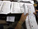 Los funcionarios realizan el conteo de papeletas de la primera vuelta de las elecciones presidenciales en un puesto de votación en El Cairo (Egipto).