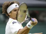 El tenista español David Ferrer golpea la bola durante el partido de octavos de final del torneo Wimbledon disputado contra el argentino Juan Martín del Potro.
