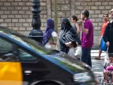 Una mujer vestida con niqab conversando en plena Rambla de Barcelona.