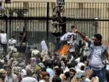 Manifestantes yemeníes saltan la valla e irrumpen en la Embajada de EE UU en Saná durante una protesta.