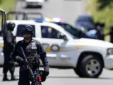 Policías federales prestan guardia mientras trabajadores forenses realizan el levantamiento de 17 cadáveres el 16 de septiembre de 2012, en la carretera que une los estados de Michoacán y Guadalajara, a la altura del municipio de Tizapan, Jalisco (México).