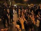 Un grupo de manifestantes se sienta ante los antidisturbios para evitar más cargas policiales.