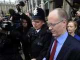El director general de la BBC, George Entwistle, rodeado de periodistas y policías a su salida de Portcullis House, donde están las oficinas del Parlamento en Londres.