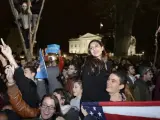 Simpatizantes demócratas sujetan una bandera de los Estados Unidos durante la celebración de la victoria del candidato presidencial Barack Obama frente a la Casa Blanca en Washington DC, Estados Unidos.