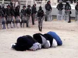 Unas mujeres jordanas rezan cercan de la policía antidisturbios durante el segundo día de protestas contra la subida del precio del petróleo, cerca de la plaza de Gamal Abdul Naser, en Amán, Jordania.