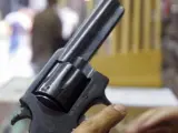 Un hombre sostiene un revólver en una imagen de archivo.