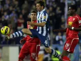 El defensa del Espanyol, Victor Sánchez (c), golpea un balón ante los jugadores del Sevilla, José Antonio Reyes (i), y el francés Geoffrey Kondogbia.