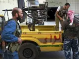 Soldados del rebelde Ejército Libre Sirio (ELS) cargan arsenal antiaéreo en una furgoneta aparcada en una calle del barrio de Shaa, en la ciudad siria de Alepo.