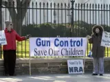 Dos defensores del control de las armas en EE UU sostienen una pancarta junto a la Casa Blanca en Washington.