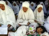 Varias personas rezan junto a las ruinas de sus casas destruidas hace ocho años por el tsunami que golpeó las costas de una docena de países bañados por el océano índico en Banda Aceh en Indonesia. Un total de 230.000 personas murieron en la catástrofe.