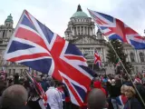 Manifestantes unionistas marchan en la capital norirlandesa en protesta por la nueva ley que estipula el izamiento de la bandera británica en el Ayuntamiento lcoal solo 17 días al año.
