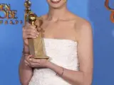 La actriz estadounidense Anne Hathaway sostiene su Globo de Oro a la mejor actriz secundaria por Los Miserables, el 14 de enero de 2013, durante la 70 edición de los premios.