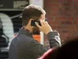 Un chico habla por el teléfono móvil.