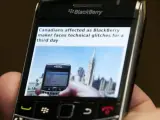 Un hombre mira su Blackberry.
