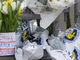 Aspecto de ofrendas con flores y mensajes colocadas junto a una barricada de la Policía cerca a la meta de la Maratón de Boston y del lugar de las explosiones.