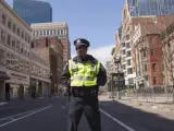 Un agente policial patrulla por la calle Boylston de Boston. Tanquetas y vehículos militares custodian la escena de los atentados de Boston, donde murieron tres personas y más de 145 resultaron heridas por la explosión de dos bombas durante la maratón de la ciudad.