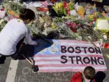 Una mujer deposita flores en la zona donde tuvo lugar el atentado en el maratón de Boston.