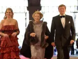 La reina Beatriz de Holanda (c), el príncipe heredero Guillermo-Alejandro (d) y su esposa, Máxima de Zorreguieta (i), llegan a la cena de gala que ofrece a los miembros de familias reales y jefes de Estado que asisten a la ceremonia de abdicación de la reina Beatriz y de investidura de su hijo primogénito, Guillermo-Alejandro.