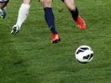 Dos jugadores disputan un balón durante un encuentro de fútbol.