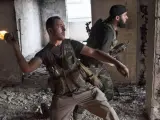 Un rebelde sirio lanza una bomba de combustible contra las tropas gubernamentales.