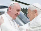 El papa emérito Benedicto XVI y el papa Francisco se abrazan tras la llegada de este último al helipuerto de Castel Gandolfo. Benedicto XVI renunció a su pontificado el 28 de febrero "por falta de fuerzas". El adiós de Benedicto es la primera renuncia papal por voluntad propia desde 1294.