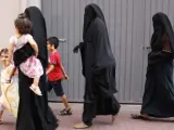 Tres mujeres con velo integral pasean por el centro de Lleida con tres niños.