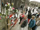 Numerosos peregrinos, visitantes y vecinos de la ciudad dejan bastones, notas, velas y flores delante de la puerta principal de la catedral de Santiago manifestando su dolor por el accidente ferroviario.