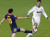 Ronaldo y Messi disputan un balón en el clásico.