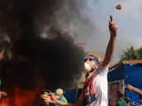 Numerosos manifestantes lanzan piedra contra las fuerzas de seguridad durante el desalojo.