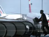 Un hombre corriendo con su equipaje por un aeropuerto.