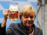 La canciller alemana, Angela Merkel, brinda con un gran vaso de cerveza.