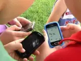 Varios niños usando sus teléfonos móviles.