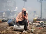 Un manifestante sentado entre los escombros se cubre el rostro durante una operación llevada a cabo por la policía para desmantelar una de las dos acampadas de los simpatizantes del depuesto presidente Mohamed Mursi.