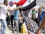 Un joven quema una bandera estadounidense en una protesta contra la posible intervención americana en Siria.