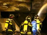 Los bomberos, luchando contra el incendio en la churrería