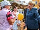 La canciller alemana, Angela Merkel (d), habla con los ciudadanos durante un acto de campaña electoral en una plaza de Barth (Alemania).