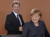 La canciller alemana, Angela Merkel, toma asiento en presencia de Guido Westerwelle.