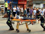 Dos personas de los servicios de emergencias transportan en camilla a un herido en los disturbios que se han producido en El Cairo y otros puntos de Egipto.