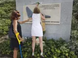 Dos componentes de la Asociación de Afectados del Vuelo JK5022 colocan una rosa blanca en el monumento a los fallecidos situado en La Rosaleda del Parque Juan Carlos I en señal de recuerdo a las 154 personas que murieron el 20 de agosto de 2008 en el accidente de un avión de la compañía Spanair en el aeropuerto de Barajas.