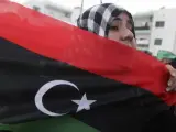 Una mujer porta la bandera de Libia en una manifestación en Misrata.