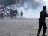 Un miembro de las fuerzas de seguridad egipcias lanza gas lacrimógeno a numerosos simpatizantes del depuesto presidente egipcio.